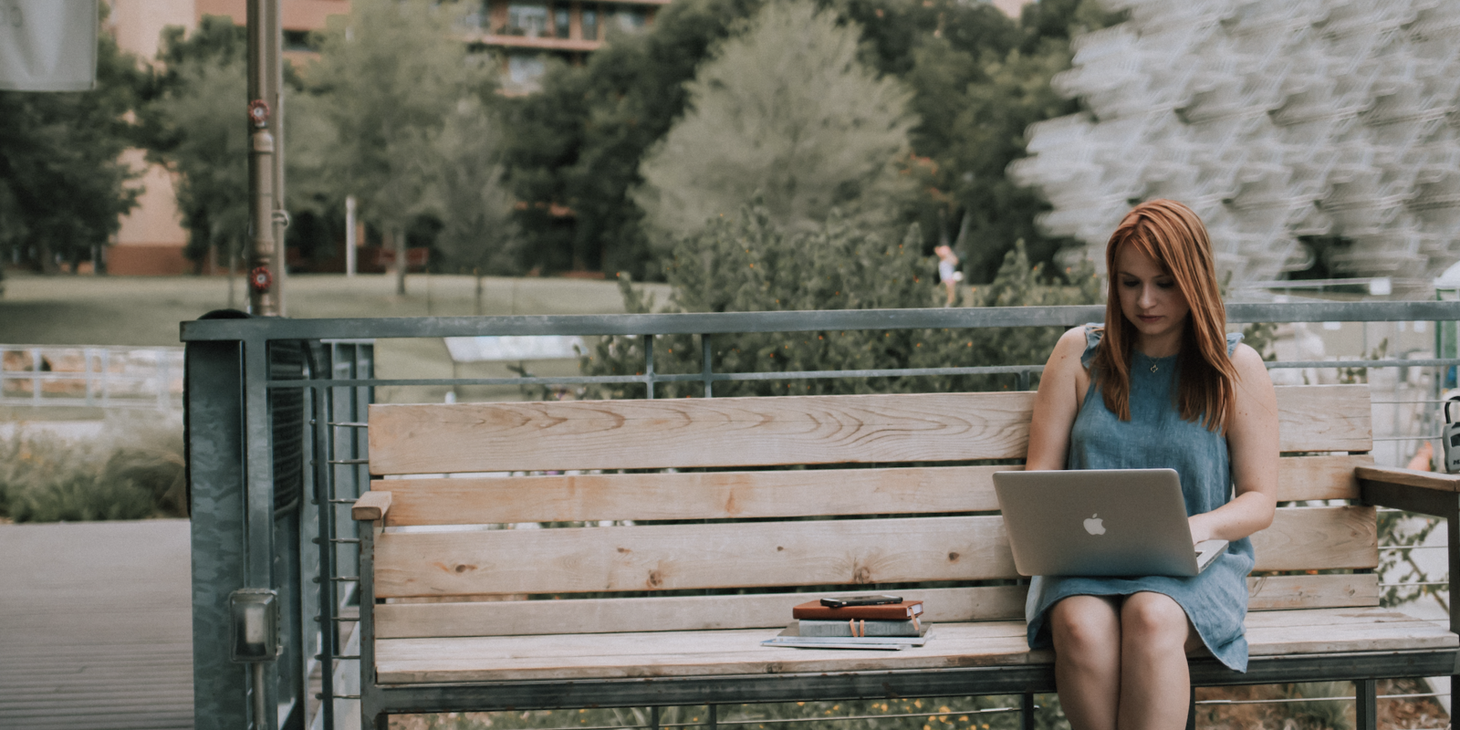 Young adult on bench on her laptop