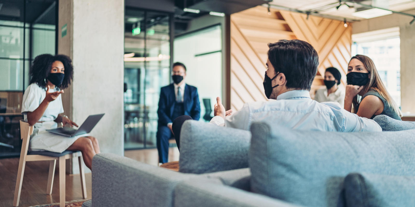 Employees sitting 6 ft a part wearing masks